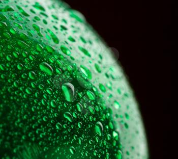 Green plastic water bottle closeup on black background