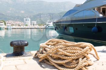 Rope and bollard on pier against yacht