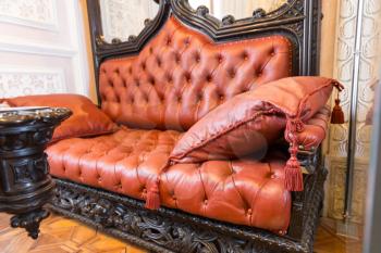 Close up of luxuroius leather-covered sofa with a pillow