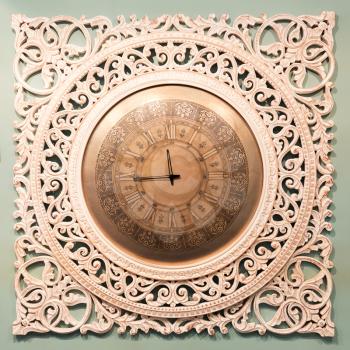 Classic clock with wooden decor on the wall with moving pointer