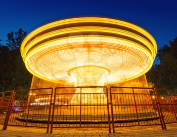 Fast merry-go-round lighting in the night park