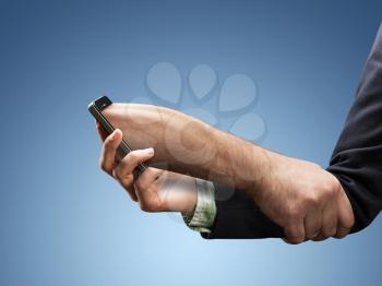 Businesswoman hand with a phone that holds it like a man's hand  - phone addiction concept