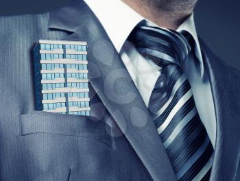 Businessman with office building in the suit pocket