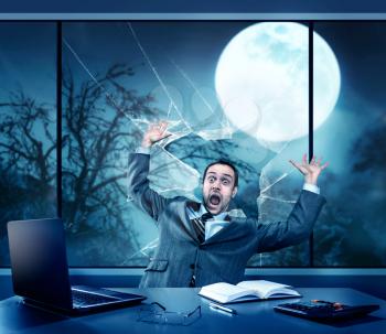 Scared businessman in the office, full moon outside
