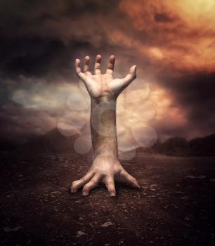 Strange human hand in the desert at night