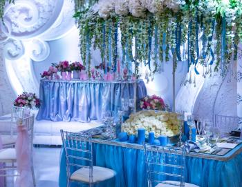 Wedding decorated restaurant with bouquets and blue candles