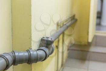 Grey plastic pipe in the corridor close up