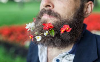 Close up portrait of homeless with flowers in his beard