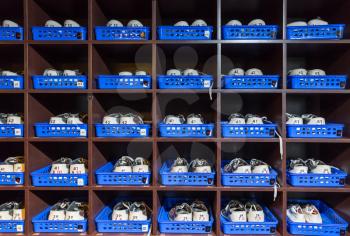 Many pairs of bowling shoes on the shelf