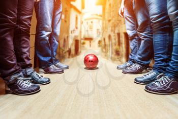 Many people standing near bowling ball in the city