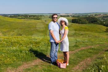 Married couple with picnic basket standing in the park