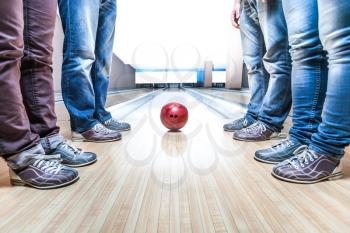 Many people standing near bowling ball on the lane closeup