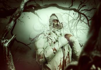 Bloody mummy at night in the forest