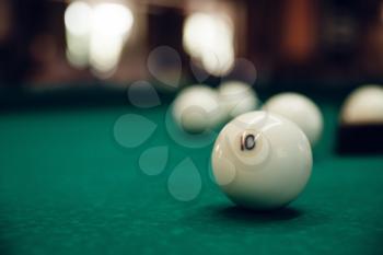 Billiard balls on the green table, one is focused