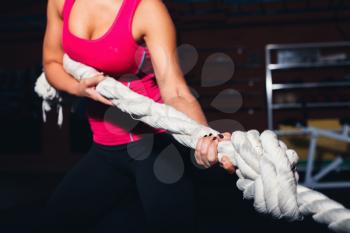 Young girl pulling rope in the gym