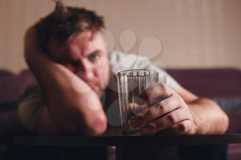 Hangover depressed man after hard drinking. Alcohol abuse problem concept.