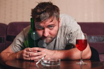 Anonymous alcoholic person in depression hard drinking alone.