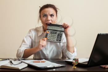 Afraid female bookkeper gnaws calculator. Scared woman bookkeeper concept