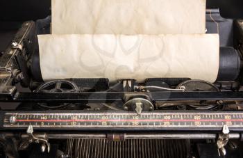 Old typewriter mechanism with inserted grunge paper sheet closeup.  