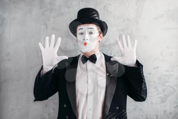Funny mime actor with makeup mask. Pantomime in suit, gloves and hat. April fools day concept