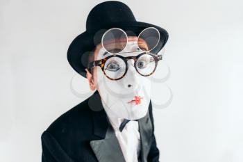 Pantomime actor face in glasses and makeup mask. Mime in suit, gloves and hat. April fools day concept