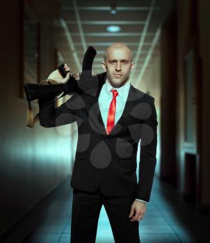 Hired murderer in suit and red tie holding machine gun in hands. Contract killer wallpaper, background or poster concept.