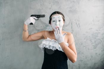 Mime female artist performing with gun. Comedian performer. Pantomime theater actress with weapon. April fools day concept
