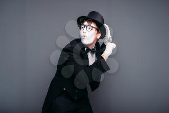 Male pantomime actor fun performing. Mime in suit, gloves, glasses, make-up mask and hat. April fools day concept