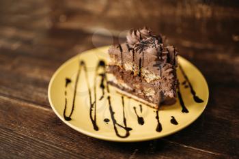 Piece of cake on the plate, culinary masterpiece on wooden background. Homemade cooking dessert