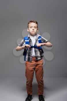 Little schoolboy with schoolbag, studio photo shoot. Young pupil in with backpack. Boy with school bag