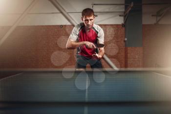Man with racket in action, playing table tennis. Ping pong training, high concentration sport