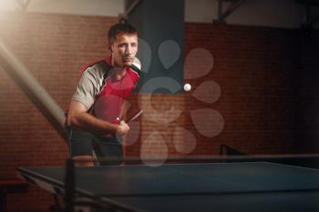 Table tennis, male player with racket in action, ball with trace. Ping pong training indoor