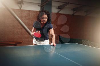 Table tennis, female player with racket and ball. Ping pong training indoor, high concentration sport game