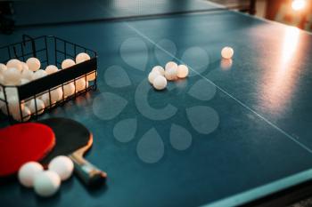 Ping pong table, rackets and basket with balls closeup, game equipment. Tabletennis concept