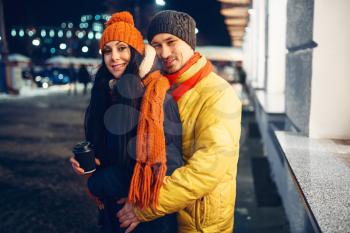 Urban winter evening, portrait of love couple outdoors. Man and woman having romantic meeting on city street