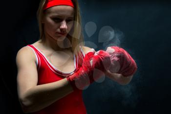 Female athlete in red boxing bandages and sportswear. Fighting sport