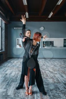 Dancers in costumes on ballrom dance training in class. Female and male partners on professional pair dancing in studio