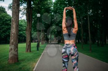 Athletic girl on fitness training in summer park. Slim woman in sportswear, outdoor fit workout