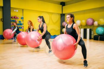 Women group with big balls, fit exercise in motion, fitness workout. Female sport teamwork in gym. Aerobic class