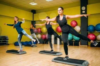 Women group on step aerobic training. Female sport teamwork in gym. Fit class, fitness exercise in motion