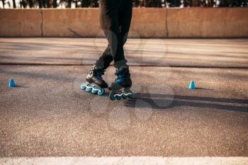 Roller skater legs in skates, balance exercise on sidewalk in city park. Male rollerskater leisure