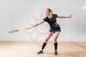 Squash game training, female player with racket in hands, indoor sport club on background