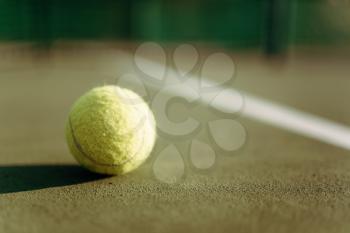 Tennis ball on ground coverage closeup, game concept. Professional sport equipment