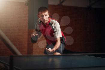 Man with racket in action, playing table tennis. Ping pong training, high concentration sport
