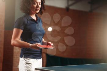 Table tennis, female player with racket hits ball. Ping pong training indoor, high concentration sport game