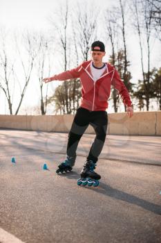 Rollerskater, rollerskating trick exercise in park. Male roller skater leisure on sidewalk