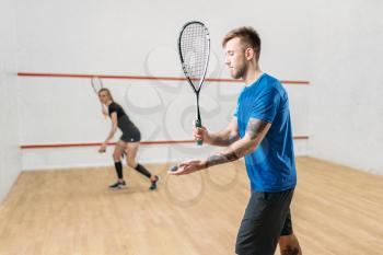 Young couple with squash rackets, indoor training club. Active sport lifestyle. Recreation workout, match with racquet