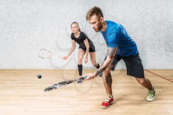 Young couple with squash rackets, indoor training club. Active sport lifestyle. Recreation workout, match with racquet