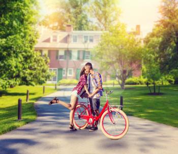 Love couple with vintage bicycle kissing in summer park, romantic date of young man and woman. Boyfriend and girlfriend together outdoor, retro bike