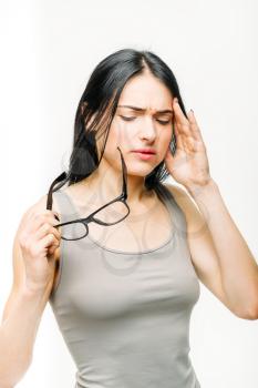 Headache, painful woman with glasses in hand, temples pain, white background. Female person in lingerie, medical advertising or concept